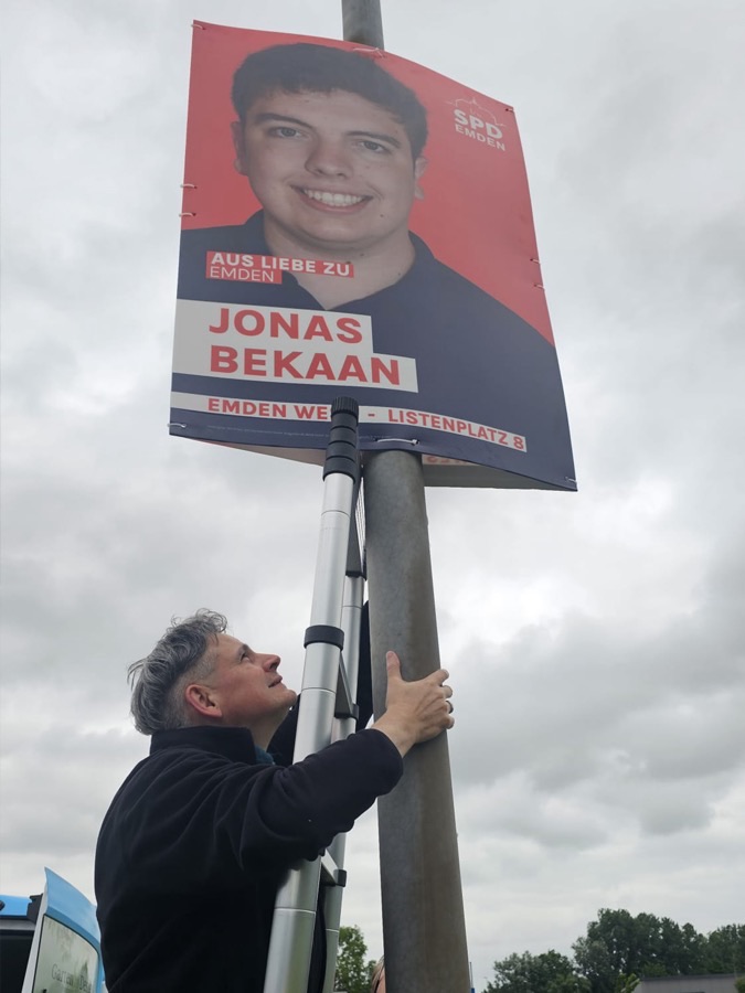 Plakat Team beim Aufhängen 1