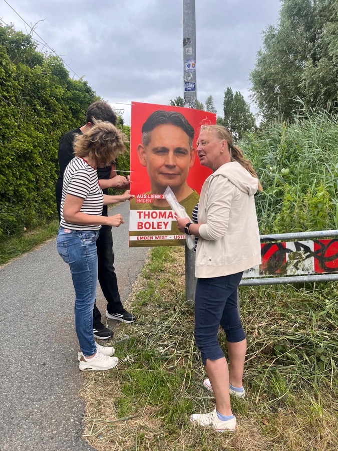 Plakat Team beim Aufhängen 2